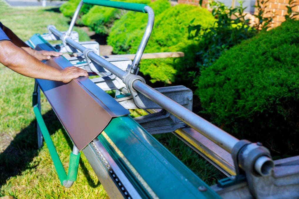 A man preparing roof guttering or flashing