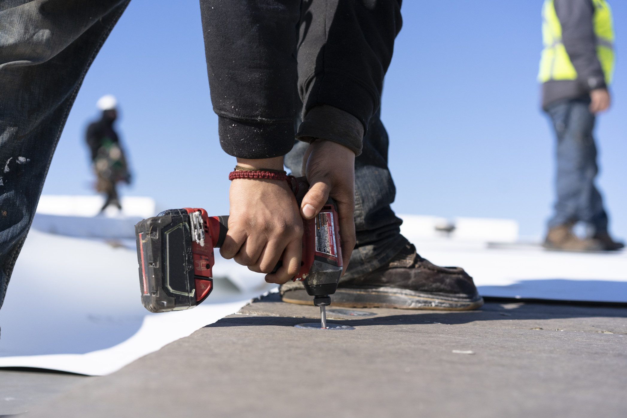 Man installing screws into commercial roof in Milwaukee