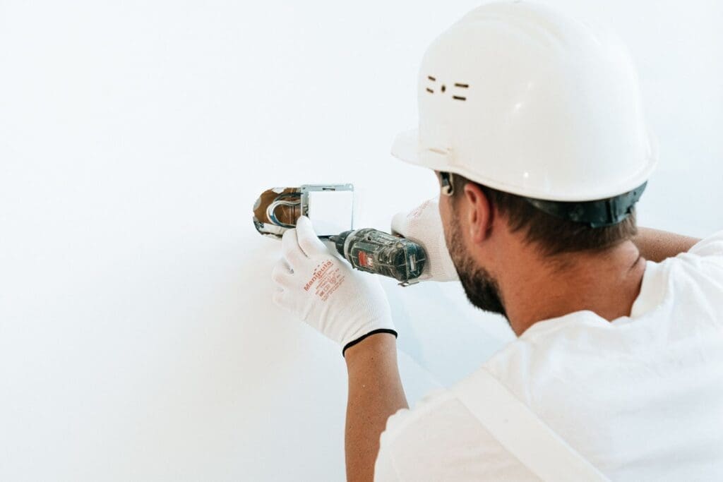construction worker fixing white wall