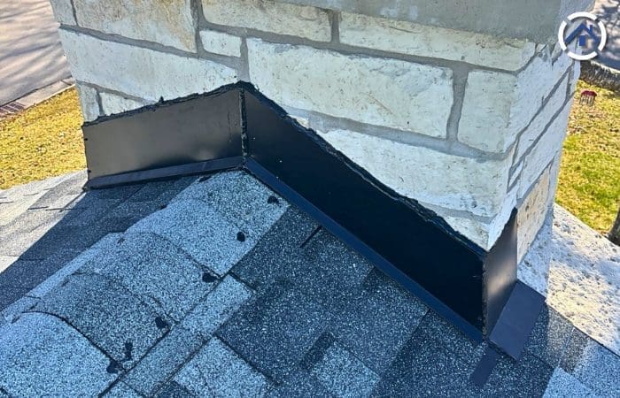 A newly installed black metal chimney flashing.