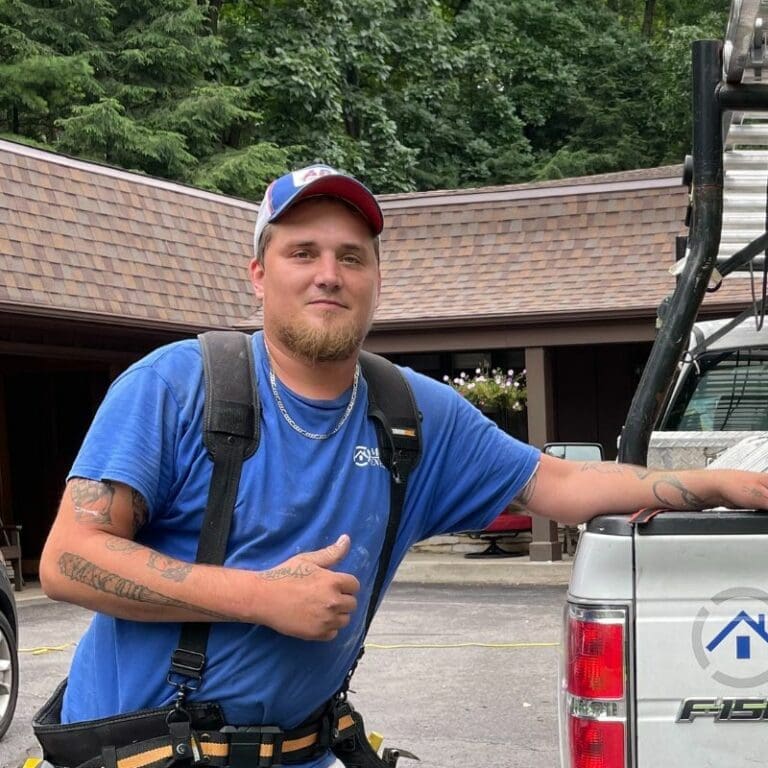 Exterior Employee giving thumbs up in front of shingles and truck