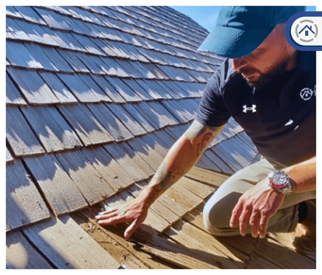 man touching the damaged part of a cedar roof