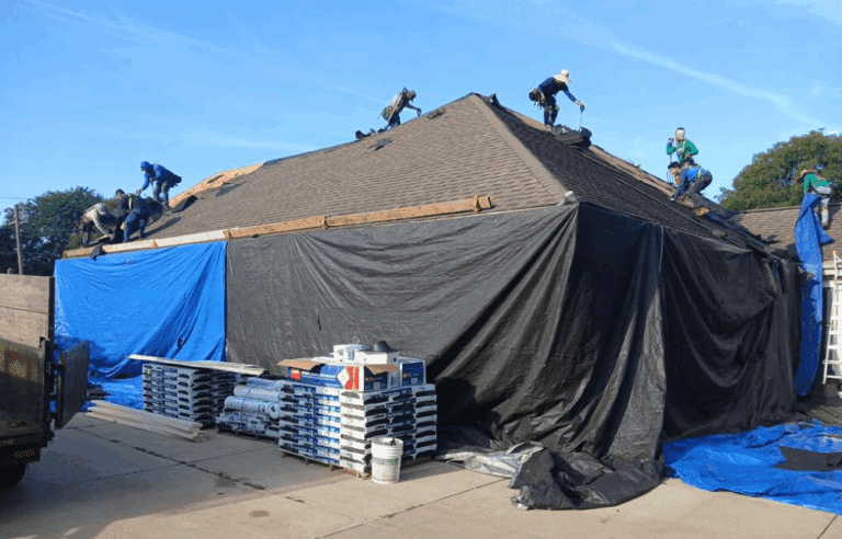 Modern Exterior crew preparing hail-damaged roof for replacement in Hales Corners, with protective tarps covering siding and landscaping
