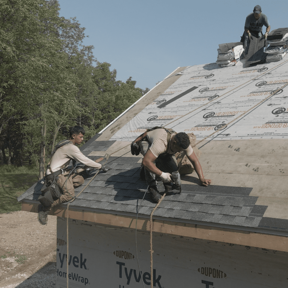 Two Modern Exterior workers in Wisconsin installing new shingles on a roof after underlayment and ice-and-water barrier installation, demonstrating professional roof replacement services.