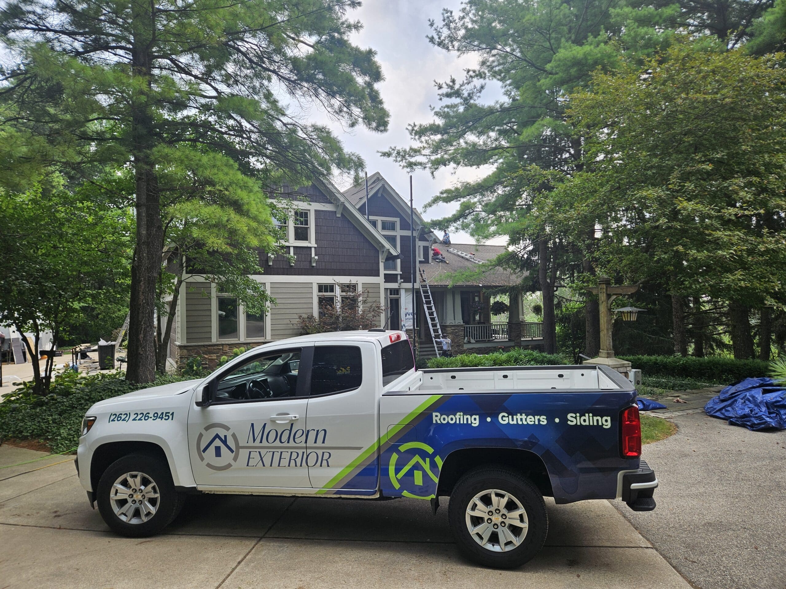 Modern Exterior truck parked in front of a home during exterior renovation, showcasing professional roofing, siding, and gutter services.