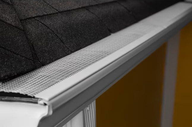 Close-up view of an Armour Guard gutter screen showing its fine aluminum mesh design that helps block small debris like dirt and roof grit.
