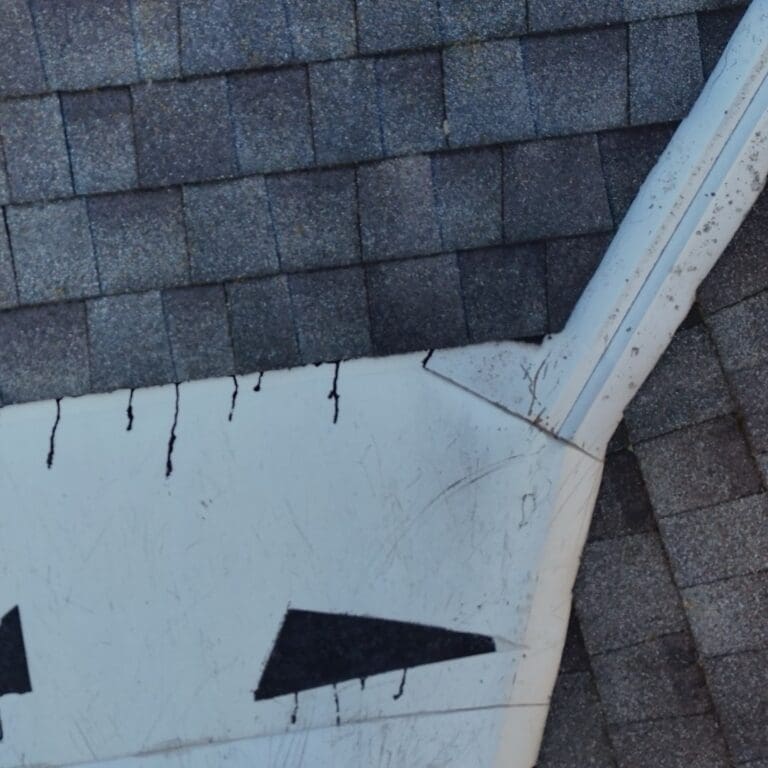 Before photo of worn roof valley with deteriorating shingles and exposed metal flashing on Brookfield home prior to roof replacement