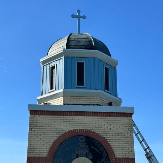 Modern Exterior repairing a leaking roof at Saint Nikola Serbian Orthodox Cemetery building in Caledonia.
