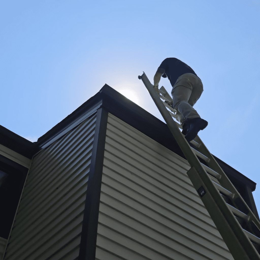 Modern Exterior roof specialist climbing a ladder to perform a free roof inspection.