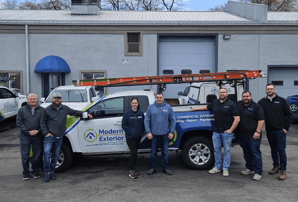 Modern Exterior commercial roofing team standing with a company truck in the office parking lot.