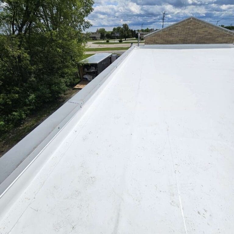 New PVC commercial roof at Central Bark Sussex with existing metal coping detail along parapet edge after roof replacement