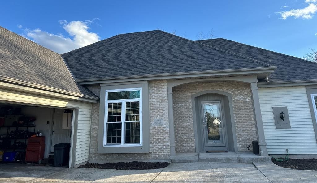 Newly completed asphalt shingle roof replacement on a residential home with clean lines and finished exterior.